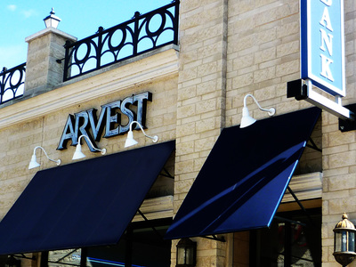 light blue Arvest sign above dark blue awning 