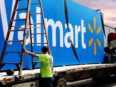 Blue Walmart sign being loaded onto back of truck