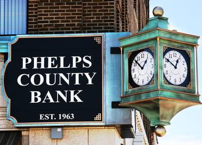 Phelps County Bank Sign EST 1963 outside of building with blue clock