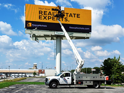 Real Estate Experts billboard being installed