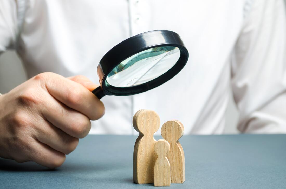 Magnifying glass looking at wooden people