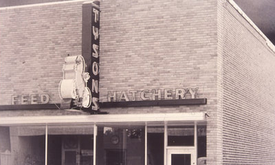 Tyson's feed and hatchery sign located on original building in vintage photo.