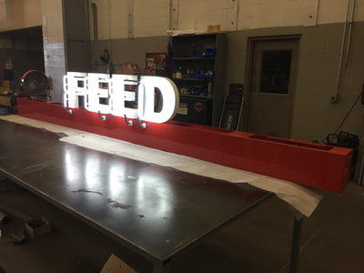 Feed neon sign being created